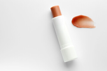 Stick of lip balm and sample on white background, top view. Space for text