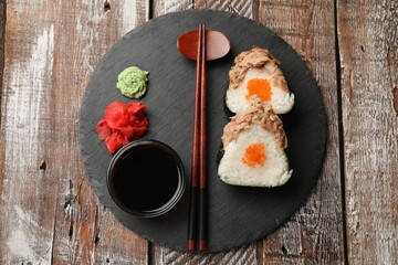 Tasty onigiri (Japanese rice balls) with tuna served on wooden table, top view