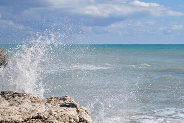 
landscape photo, sea waves crashing against a rocky shore