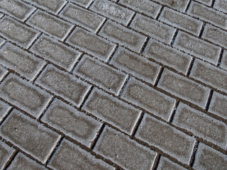 Oversalted path surface with white salt grains on icy sidewalk in a dry and cold winter. Applying salt to keep roads clear