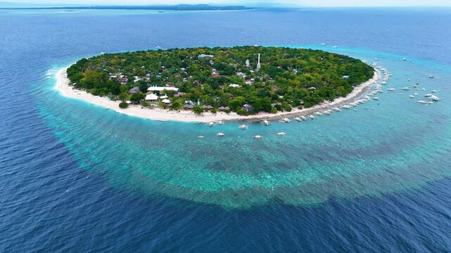 Balicasag Island Panglao Bohol. Panoramic drone 4K aerial drone video footage view of lonely round island in Philippines with many traditional Philippines boats