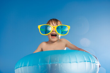 Happy child playing in waterpark. Kid having fun on summer vacation