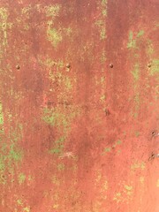 Abstract rusty metal texture with shades of red, orange, and green, close-up photography