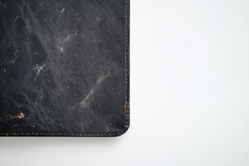 Close-up of a worn, black leather surface with visible scratches and dust.
