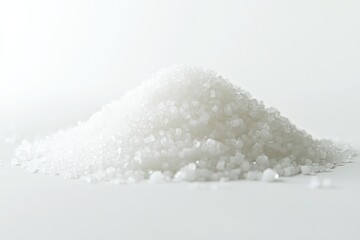 A close-up shot of a pile of white sugar crystals on a white background.