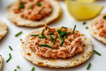 Salmon appetizers with chives on crackers and lemon slices.