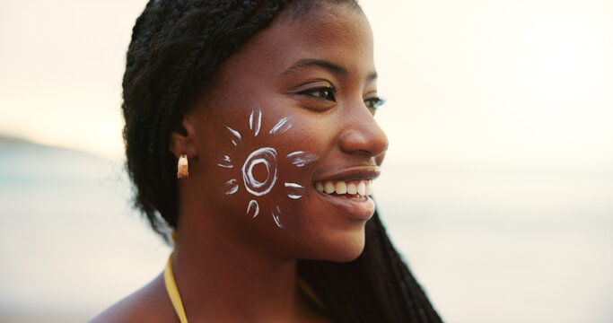 Beach, face and black woman with sunscreen for skincare, uv protection or beauty at sunset. Ocean, sun cream drawing and spf cosmetics for dermatology, adventure or travel to relax on holiday