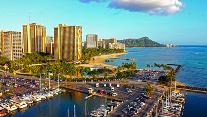Obraz premium Waikiki Beach Skyline with Diamond Head View. Aerial view of Waikiki Beach in Honolulu with high-rise hotels, a marina, and Diamond Head crater in the distance.