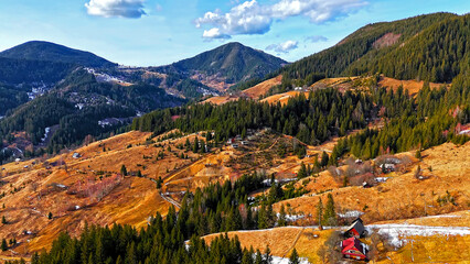 Colorful Mountain Valley with Forest and Cabins. Vibrant aerial view of a mountain valley dotted...