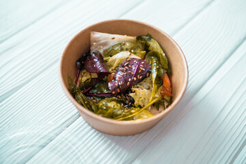 Closeup of fresh healthy salad in a a zero waste container to go. Food delivery, healthy food concept.