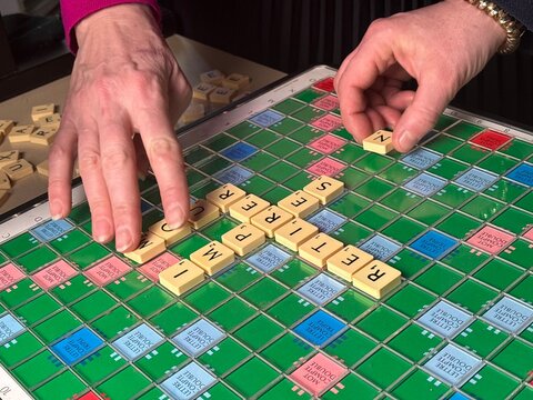 jeu de scrabble de luxe  avec mains en cours de partie, d&eacute;tente et jeu de soci&eacute;t&eacute;