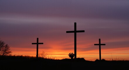 Silhouetted wooden crosses against a vibrant sunset sky symbolizing hope and reflection during a sacred moment
