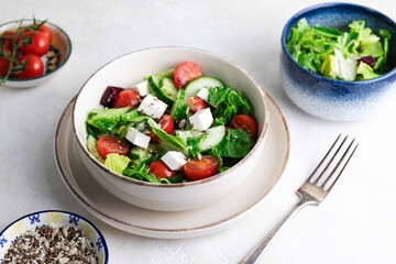 Greek salad with fresh tomatoes, cucumbers, lettuce, feta cheese and seeds.