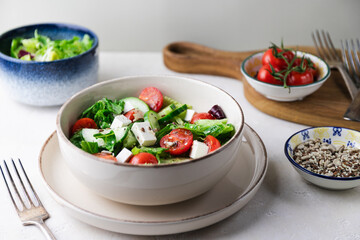 Greek salad with fresh tomatoes, cucumbers, lettuce, feta cheese and seeds.