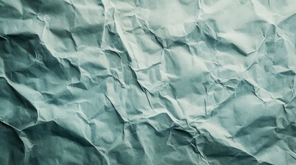 Fototapeta premium A light blue crumpled paper background showing deep folds and texture details. It's great for graphic design projects, backdrops, or adding texture.