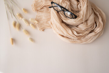 glasses and scarf on a beige background. Flat lay, top view, blog, website, social media concept....