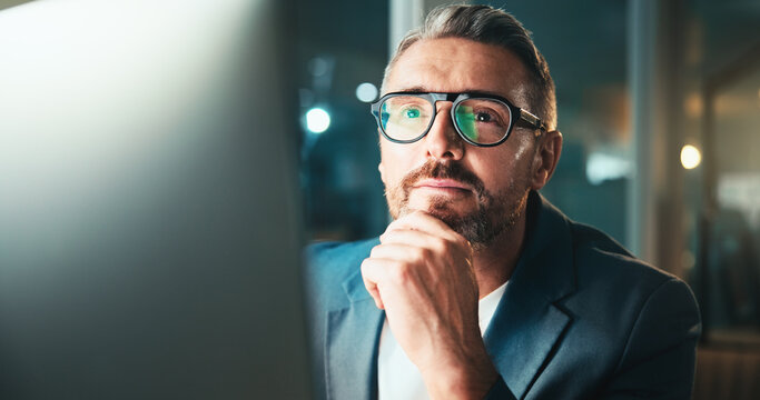 Man, developer and glasses on computer at night for programming website, software update or deadline. Mature person, online and reading research for problem solving, system error and solution process