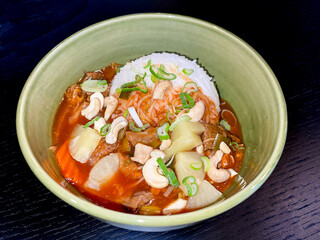 sweet and sour chicken and fruits dish with rice in green bowl, high angle view, close up