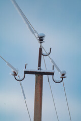 Fototapeta premium Telegraph pole with wires on the background of blue sky, landscape