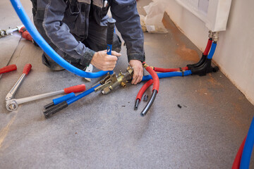 A Skilled Plumber Installing Color Coded Piping Throughout a Large Construction Project