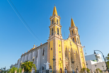The striking yellow facade and bell towers of the Cathedral Basilica de la Inmaculada Conceptión,...