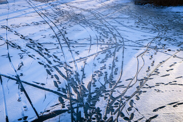  Pattern of multiple traces of people and bicycles in the snow on a frozen river