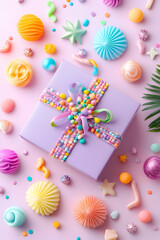 Obraz premium Pastel gift box surrounded by colorful candy and decorations on pink background