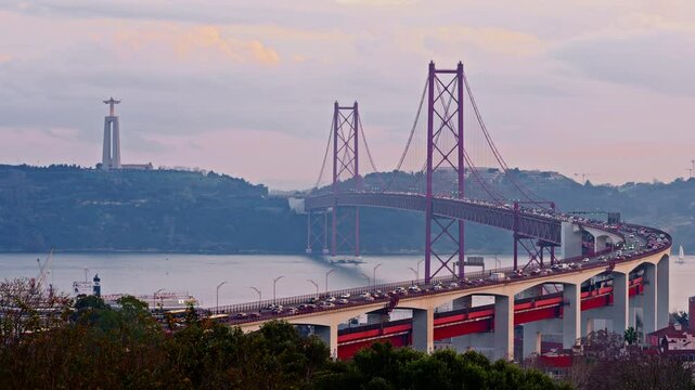 Bridge at sunset from Miradouro do Bairro do Alvito tourist viewpoint with Tagus river, traffic on 25th of April Bridge at sunset. Lisbon, Portugal