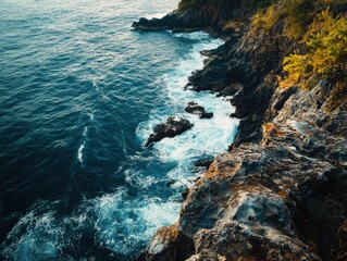 Obraz premium Scenic coastal landscape with dramatic waves crashing against rugged cliffs and rocky outcrops.