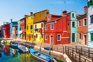 Burano island canal, colorful houses and boats in the Venice lagoon. Italy