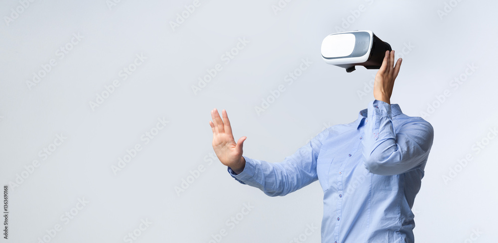 Leinwandbilder A user experiences virtual reality by wearing advanced goggles. The person is isolated against a neutral background, actively engaging with digital environments without a visible head.