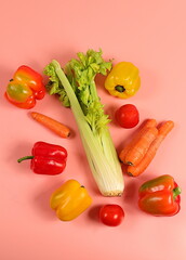 Sweet bell peppers, tomatoes, celery and carrots on a light table. Modern still life of various ripe vegetables for healthy vegetarian food and detox diet, harvest. Advertisement of a store 