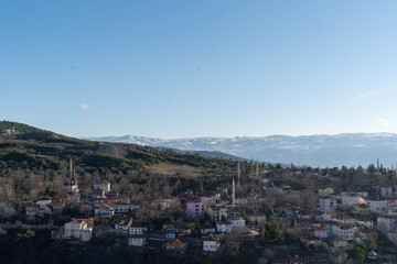 Hillside Town with Snow-Capped Mountains