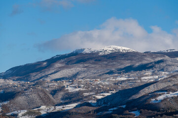 Valley Town Surrounded by Partially Snow-Capped Mountains