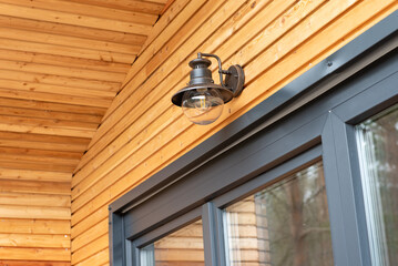 modern modular house in the forest. modern outdoor light on a wall of a wooden house or bungalow.