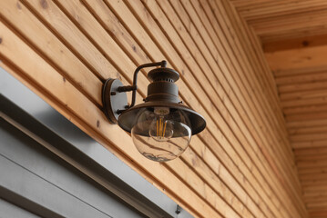 modern modular house in the forest. modern outdoor light on a wall of a wooden house or bungalow.