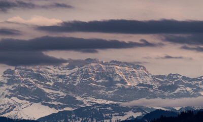 Snowy mountain landscape under cloudy sky during twilight hours in a remote location