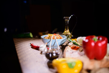 Colorful array of fresh ingredients and pasta prepared for a gourmet meal in a cozy kitchen setting