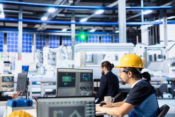 Photovoltaics factory employee programming solar manufacturing machinery using PC, finetuning...