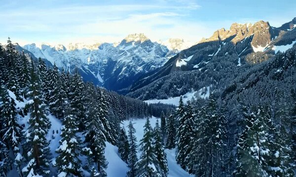 Flight through the winter forest in the mountains. Aerial view of Beautiful landscape of nature. 4K