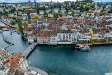 Obraz premium Stunning aerial footage of Kapellbrücke, the iconic Chapel Bridge, showcasing the picturesque beauty of Lucerne, Switzerland.
