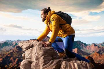 Nature lover stands at the edge of a breathtaking mountain range, looking at the scenic background...