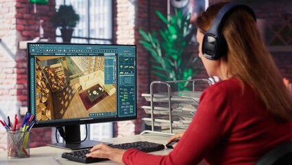 Professional architectural designer configures a floor plan on dual monitors, utilizing computer...