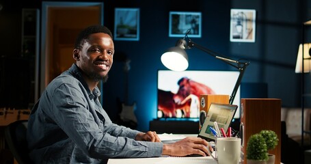 Self employed person working from home and researching different topics, examining online archived information and planning his daily tasks. Remote job setup increasing productivity. Camera A.