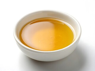 A small bowl of golden cooking oil on a white background.
