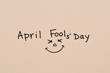 A simple doodle for April Fools' Day with handwritten style text and a playful smiley face on a beige background.  The face adds a lighthearted, humorous touch.