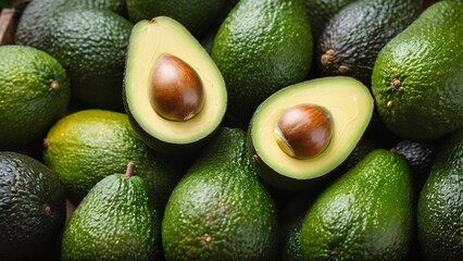 Lots of avocados with halved avocado with seeds in a pile, vegan food