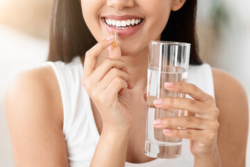 Diet, nutrition, healthy eating concept. Close Up Of Happy Smiling Asian Woman Taking Supplement...