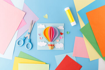 Paper art project featuring a 3D hot air balloon. DIY handmade craft with bright colors, scissors,...