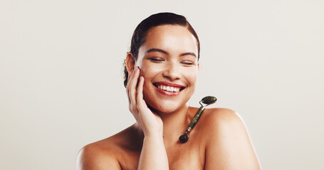 Smile, woman and roller for skincare in studio for facial massage, blood circulation and treatment....